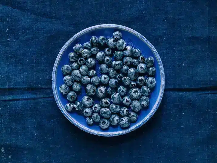 Een blauw bessenvergiet uit klei met daarin blauwe bessen