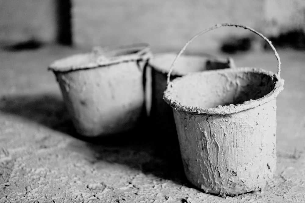Drie emmers vol gedroogde klei voor keramiek