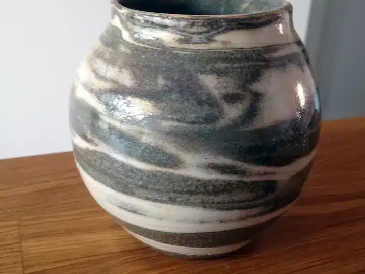 Een bolle vaas gemaakt door verschillende kleikleuren mengen gekleurd