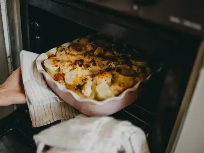 Een ovenschotel van klei in de oven gevuld met een gerecht