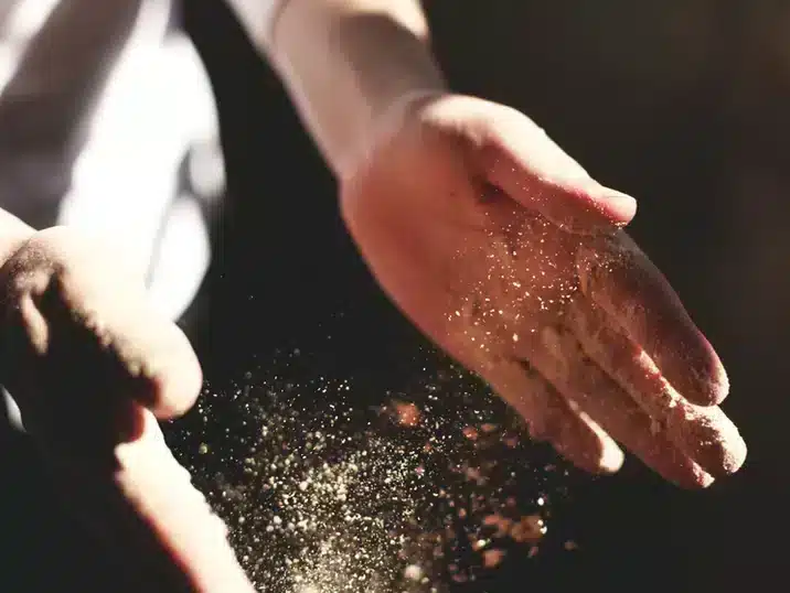 Atelier stofvrij houden: Handen die stof afschudden in een klei-atelier