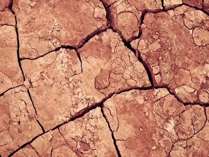 Een detail van gebarsten rode grond klei