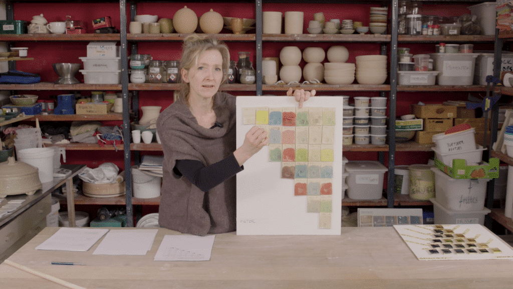 Glazuur recept keramiek: Aster Caemaert in haar atelier met testplaatjes geglazuurde keramiek volgens de multimengmethode
