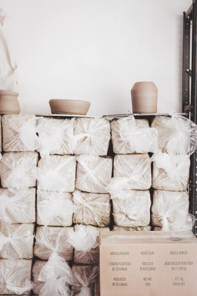 een hele hoop pakken klei op een stapen in het atelier, klei bewaren