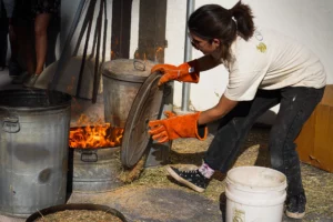 Raku in keramiek: een vrouw terwijl ze in tonnen vuur maakt voor het raku stoken van keramiek