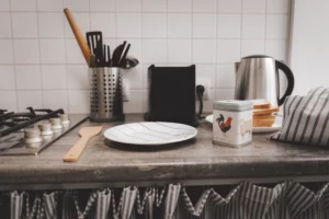 Aanrecht in de keuken met lepel, bord en potje met haan en schaap op