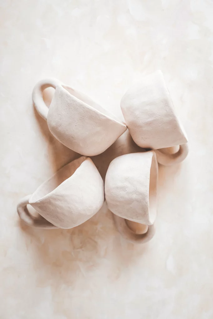 4 koffie kopjes met oor gemaakt van witte bicsuit tijdens handopbouw keramiek