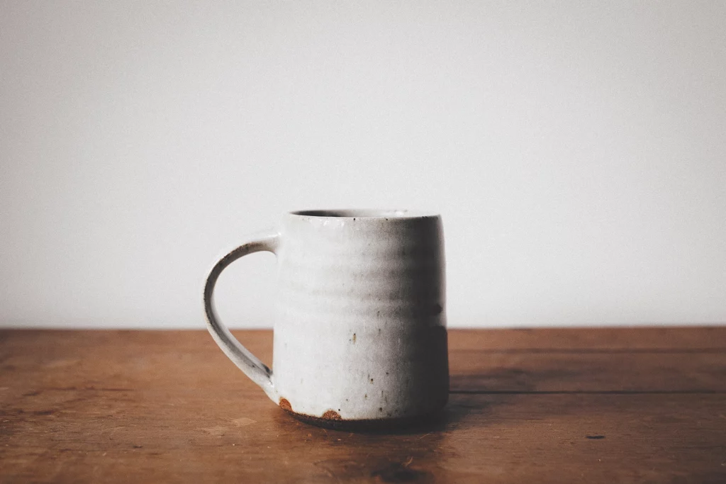 een koffiekopje gemaakt van witte klei tijdens handopbouw keramiek