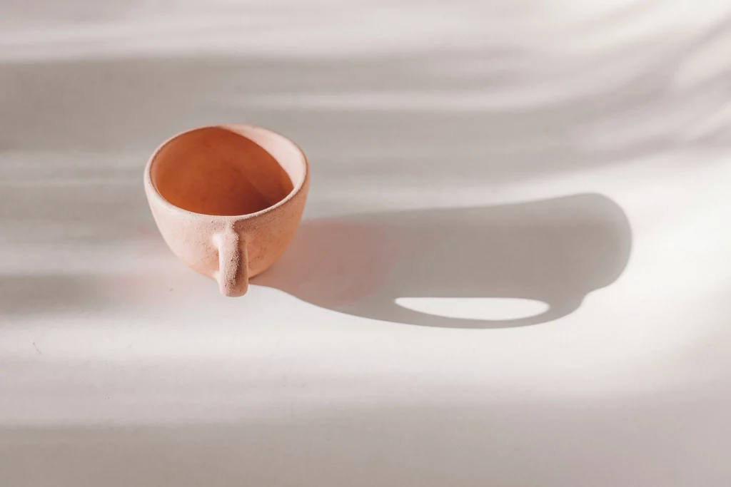 een koffiekopje gemaakt van rode klei tijdens handopbouw keramiek