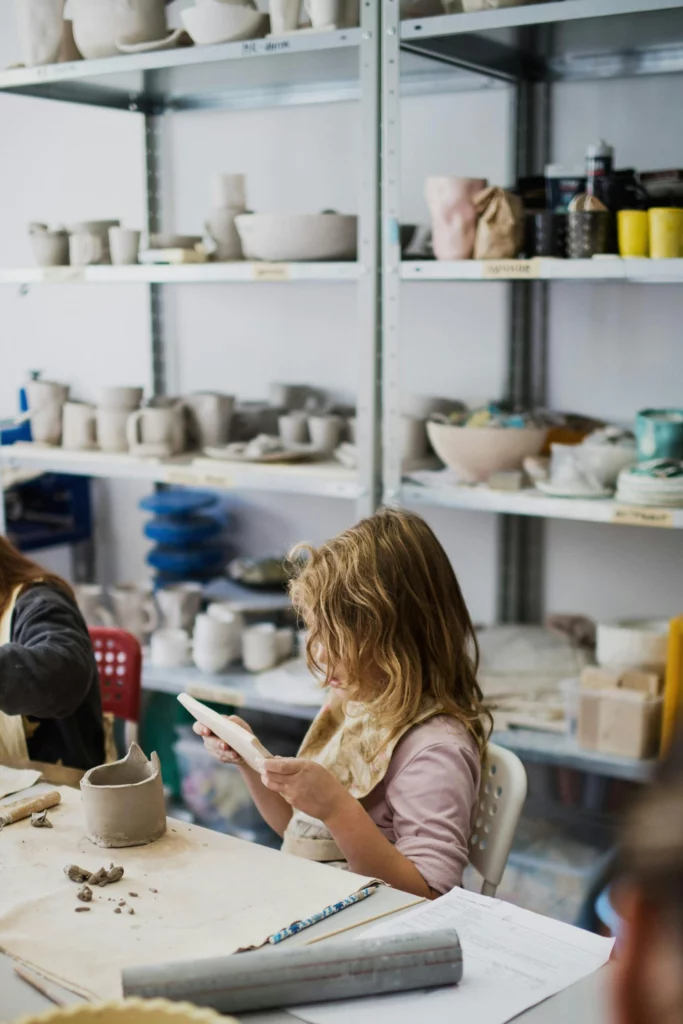 Kind in open atelier opbouw met klei